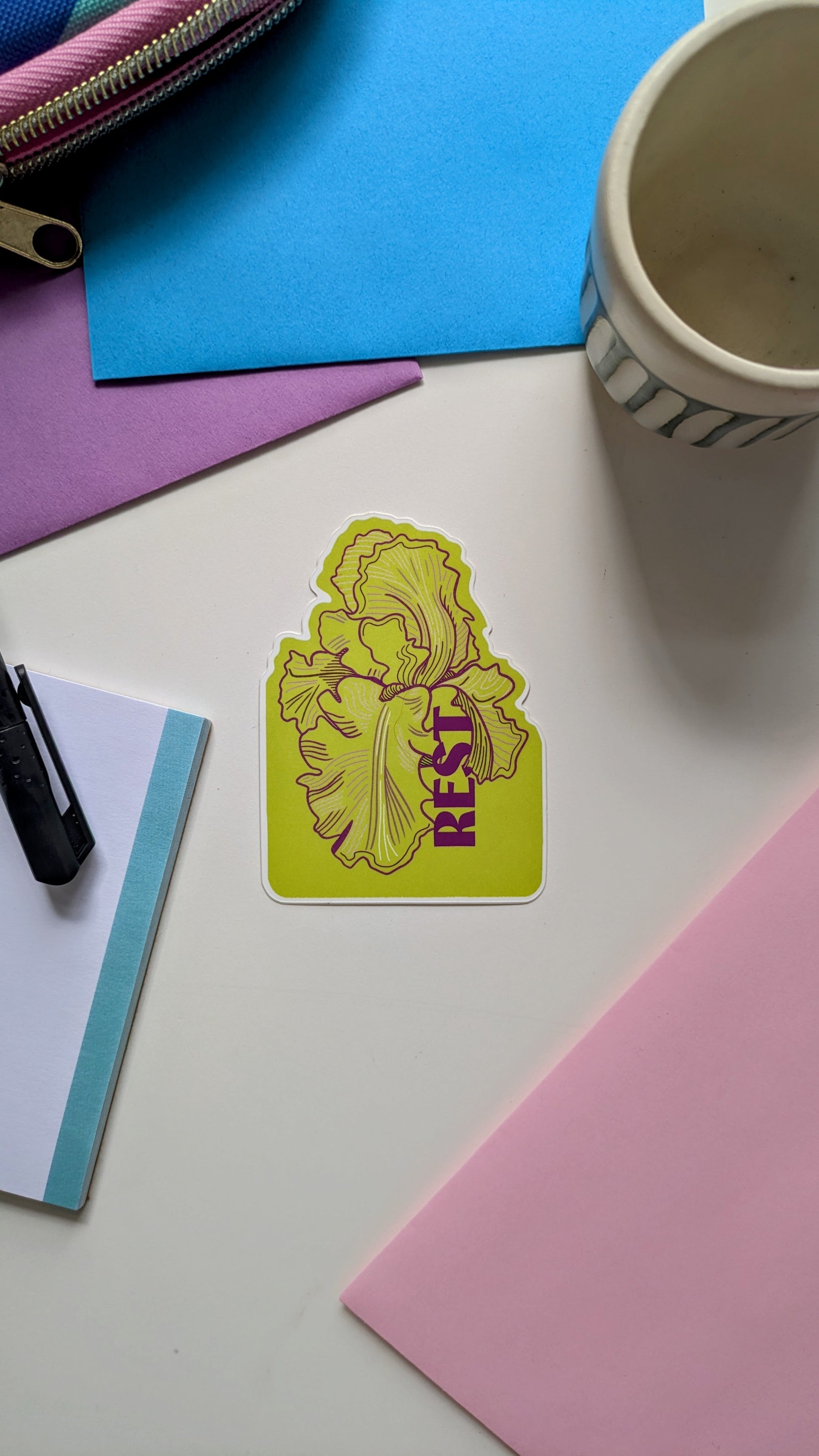 Nature illustration sticker featuring a bearded iris with the word "rest" in lime green and purple tones.