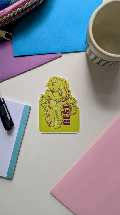 Nature illustration sticker featuring a bearded iris with the word "rest" in lime green and purple tones.